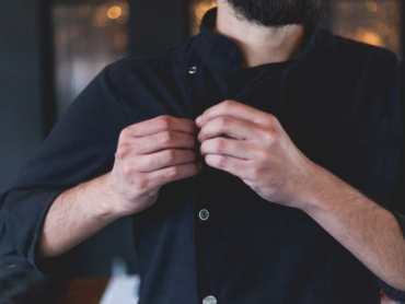 Employee adjusting a professional work uniform jacket, highlighting workplace uniform comfort, fit, and employee satisfaction.