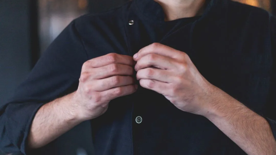Employee adjusting a professional work uniform jacket, highlighting workplace uniform comfort, fit, and employee satisfaction.